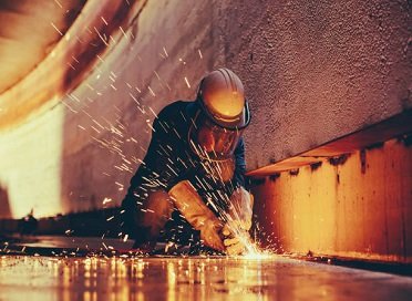 Steel plate being torch-cut with sparks